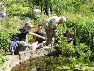 Vrijwilligers en bezoekers genieten in de Naturentuin